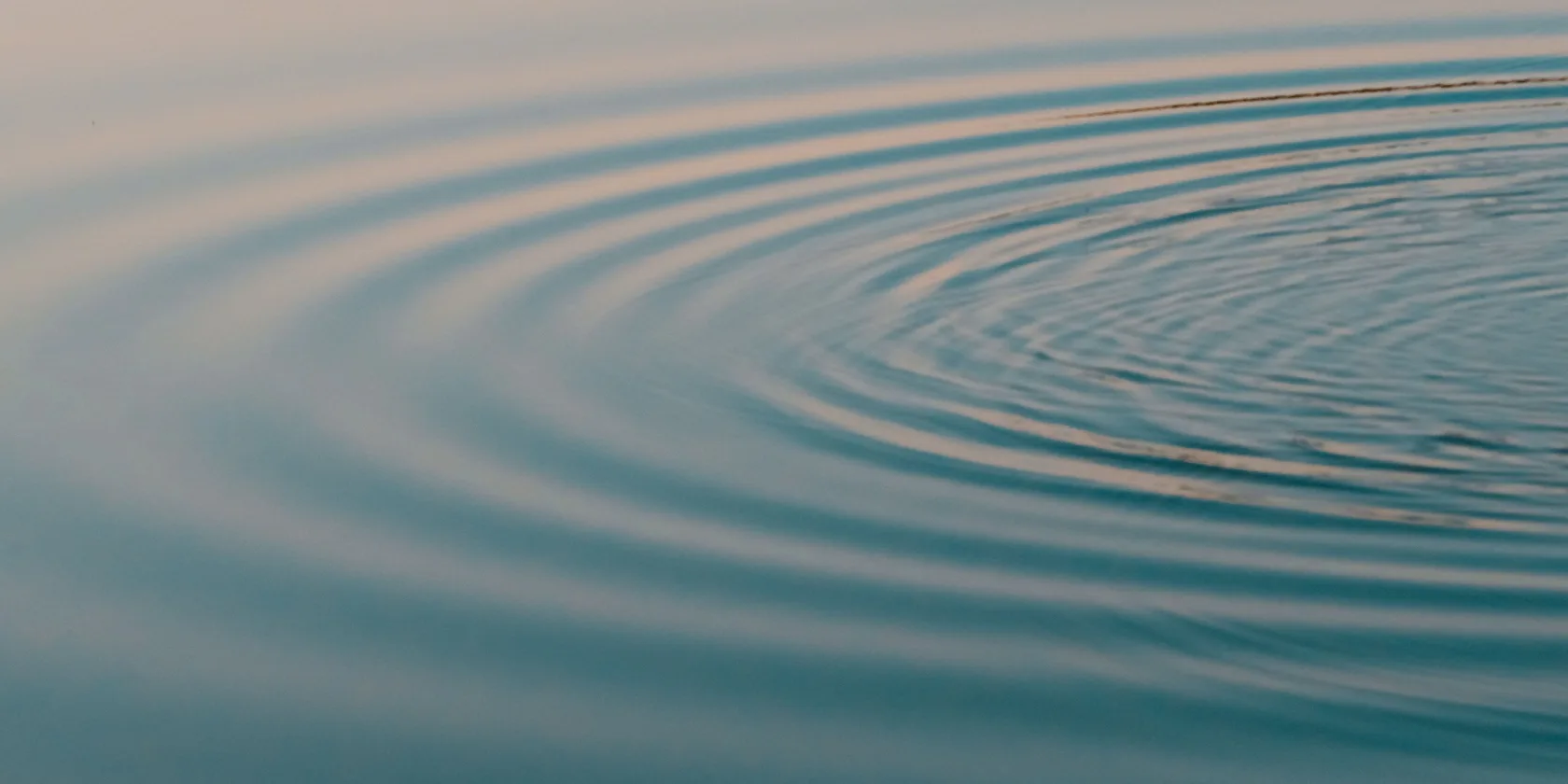 Ondes concentriques à la surface calme de l'eau, reflets apaisants